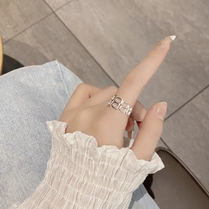 Macro view of wide silver ring featuring a continuous镂空 hollow letter B pattern