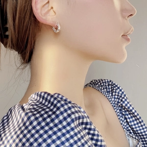 Close-up of minimalist silver hoop earrings featuring a unique hammered metal texture