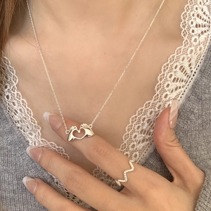 Detail of S925 sterling silver heart gesture pendant necklace and twisted wave ring