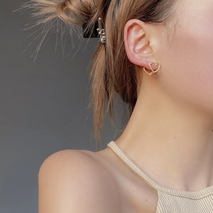 Elegant 925 sterling silver heart-shaped gold earrings worn by a model in a close-up view