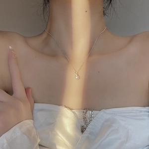 Elegant 925 sterling silver necklace featuring a round white pearl pendant on neck