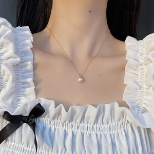 Elegant 925 sterling silver necklace with a round pearl pendant on a gold chain