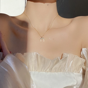 Close-up of a gold S925 sterling silver crescent moon pendant on a delicate chain