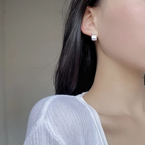 Close-up of minimalist S925 sterling silver rectangular earrings worn by a female model