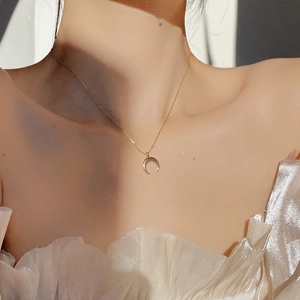 Elegant 925 sterling silver gold crescent moon necklace worn on a woman's collarbone