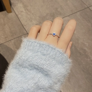 Detail of S925 sterling silver twist ring with a heart-shaped blue zircon on finger