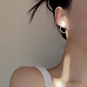 Détail de boucles d'oreilles argentées géométriques et rondes pour un style minimaliste
