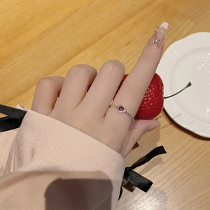 Close-up of S925 sterling silver heart ring with red zircon on model's hand