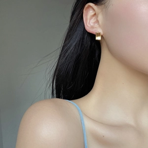 Elegant gold square geometric earrings worn by a model in a minimalist style