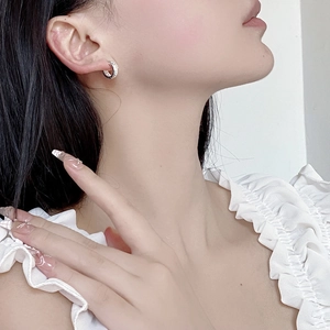 Close-up of S925 sterling silver earrings with hammered texture on a model's ear