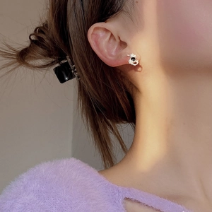 Close-up of S925 silver stud earring featuring irregular texture and black onyx center