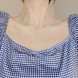 Close-up of S925 sterling silver phoenix tail chain necklace worn on a model's neck