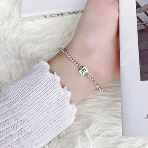 Macro detail of S925 sterling silver mahjong bracelet featuring green beads and Fa pendant