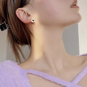 Close-up of irregular gold S925 silver stud earring with black stone on a model
