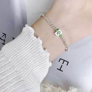 S925 sterling silver beaded bracelet with green Mahjong fortune charm on a hand