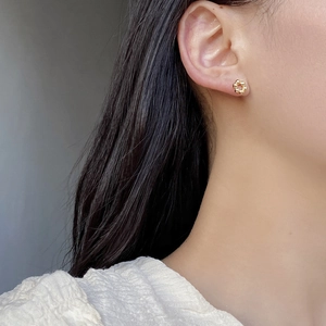 Elegant 925 sterling silver hollow flower stud earrings in gold finish worn by a model