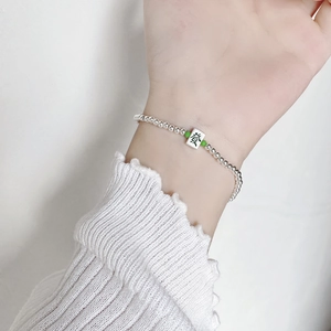 Detail of S925 silver beaded bracelet featuring a Mahjong charm with green accent beads