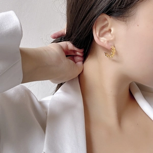 Minimalist 925 sterling silver golden C-shape earrings with textured wave design on model