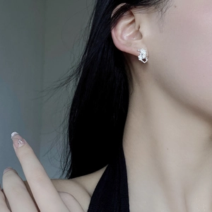 Close-up of irregular textured S925 silver stud earring on ear with molten metal design