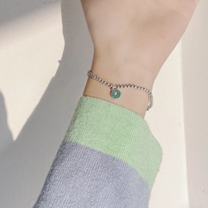 Détail macro du bracelet en argent S925 avec pendentif beignet en émail bleu sarcelle
