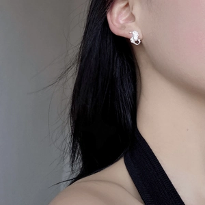 Irregular textured S925 sterling silver stud earring with center zircon worn on ear