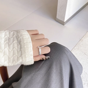 Detail of S925 sterling silver wheat ear ring on model finger with braided texture