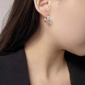 Detailansicht der strukturierten S925 Silberohrringe am Model mit schwarzem Blazer-Outfit