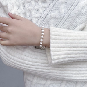 Close-up of S925 silver and natural baroque pearl bracelet worn on a woman's wrist
