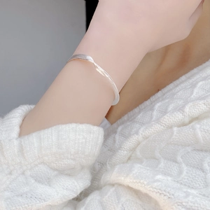Minimalist 925 sterling silver twisted bangle with brushed finish on a knitted sleeve