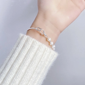 Minimalist S925 silver irregular branch bracelet with baroque pearls on a model's wrist