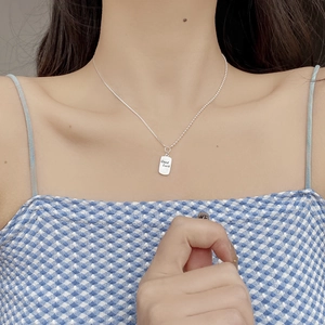 Detail of S925 silver beaded chain necklace with Good Luck engraved square pendant
