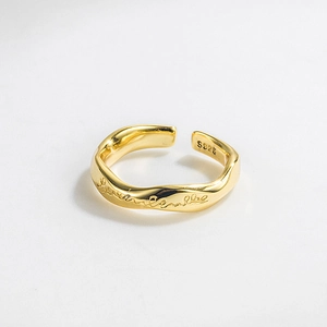 Close-up of S925 sterling silver stamp on golden Mobius ring with wavy texture