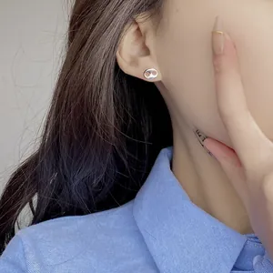 Close-up of minimalist s925 silver pig nose stud earrings worn by a female model