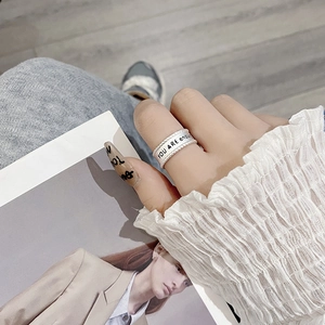 Detail of twisted silver ring with 'YOU ARE enough' engraving on a lifestyle background