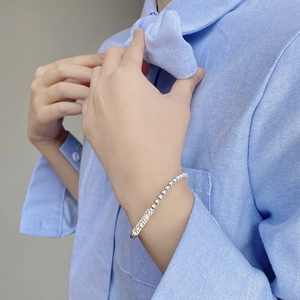 Bracciale di perline in argento S925 con scritta Lucky sul polso del modello