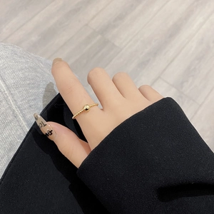 Detailed close-up of a minimalist gold beaded silver ring worn on a finger