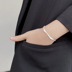 Bracelet vague en argent sterling S925 mat sur mannequin avec costume noir en fond
