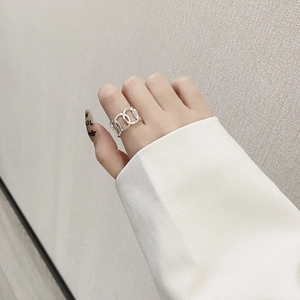Detail of minimalist 925 sterling silver hollow chain ring worn on a finger