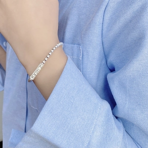 Primo piano del bracciale con perline in argento S925 e ciondolo Lucky inciso sul polso