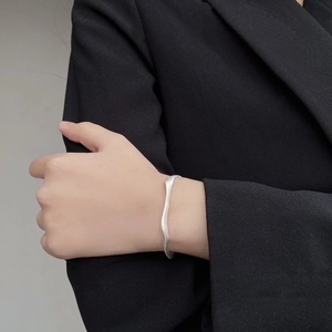 Gros plan d'un bracelet vague en argent sterling S925 mat avec texture métal brossé