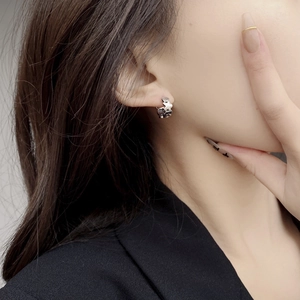 Close-up of vintage 925 sterling silver hoop earring with embossed cross flower patterns
