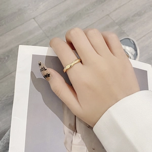 Detailed view of a gold Mobius wave ring with a high-polished finish and irregular texture