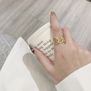 Minimalist 925 sterling silver hollow interlaced rings shown on a finger with a cup