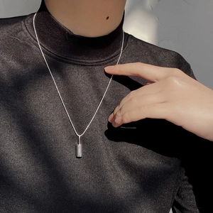Minimalist S925 sterling silver cylinder pendant necklace on a black turtleneck