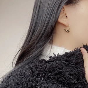 Textured gold hoop earrings with vintage hammered surface worn by a model in a close-up