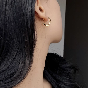 Minimalist S925 sterling silver twisted golden hoop earrings worn by a model