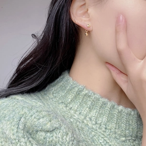 Detail von S925 Silber Goldperle Ohrringen, getragen mit grünem Strickpullover