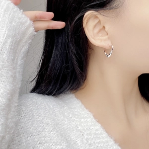 Minimalist S925 sterling silver twisted hoop earrings on model shown from side view