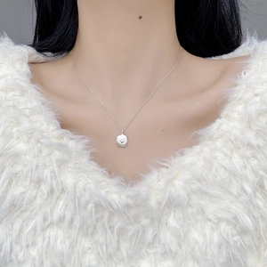 Minimalist S925 sterling silver necklace with heart-engraved oval pendant on a model