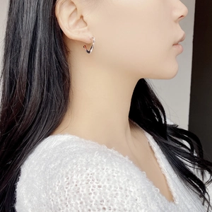 Macro shot of S925 sterling silver twisted V-shape earring worn by a model